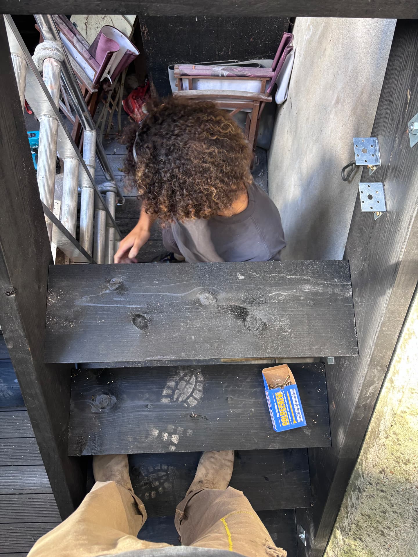 Fixing charred timber rails to the terrace frame with galvanised brackets
