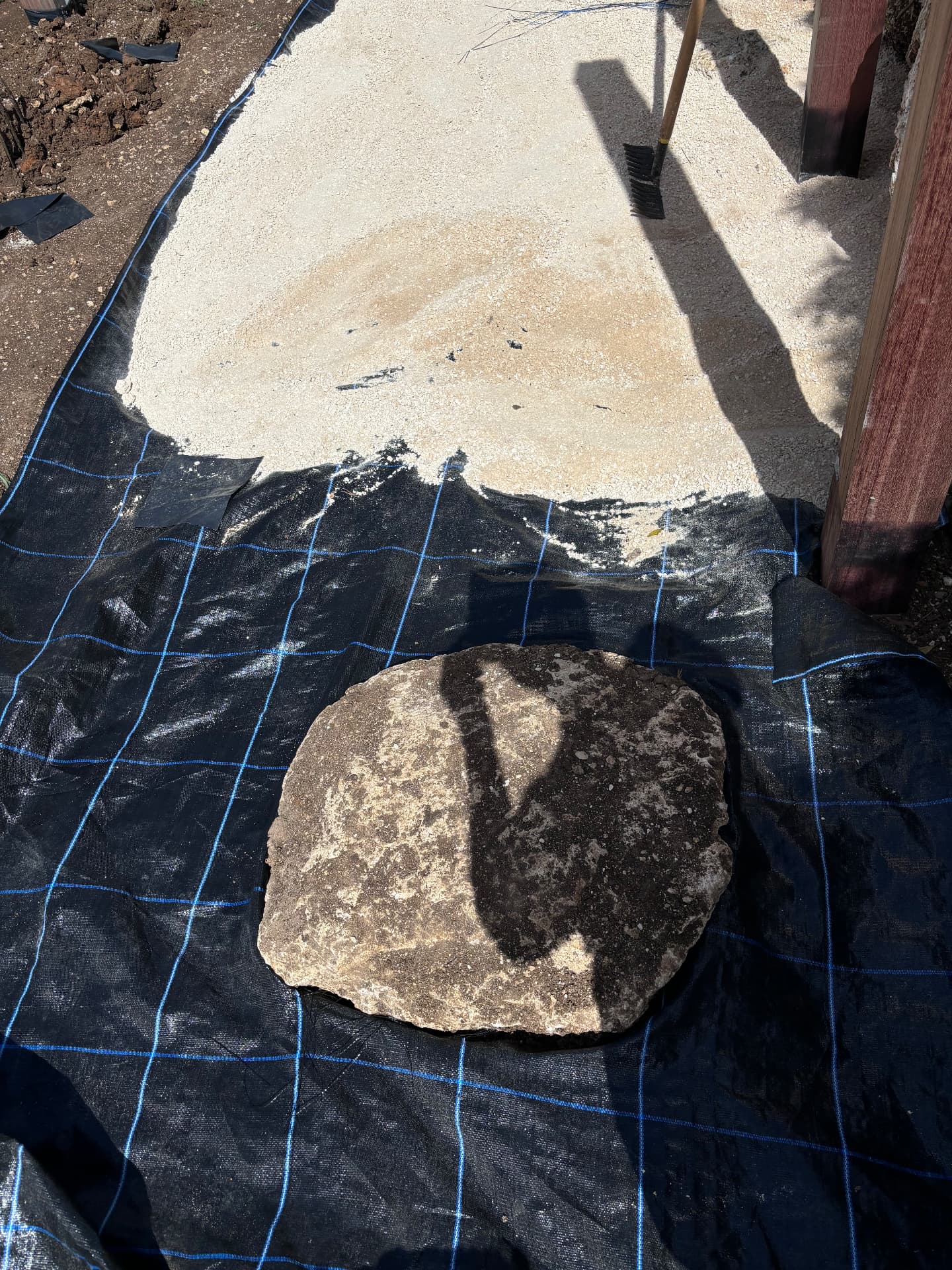 Coral stepping stone laid out on membrane before gravel is spread