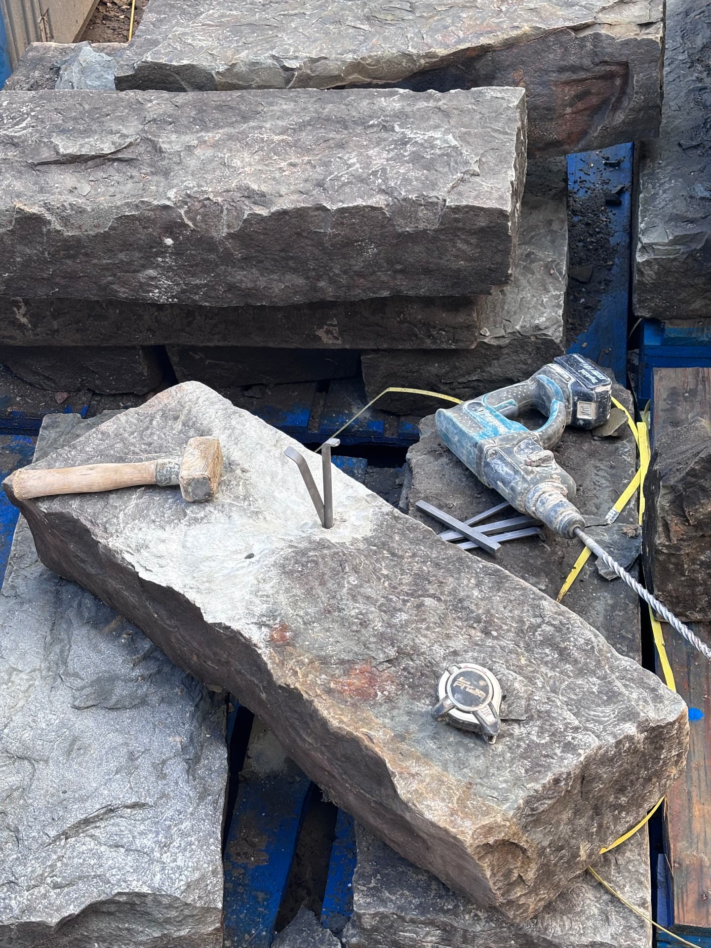 Sandstone step blocks on a pallet with mallet, pins and hammer drill