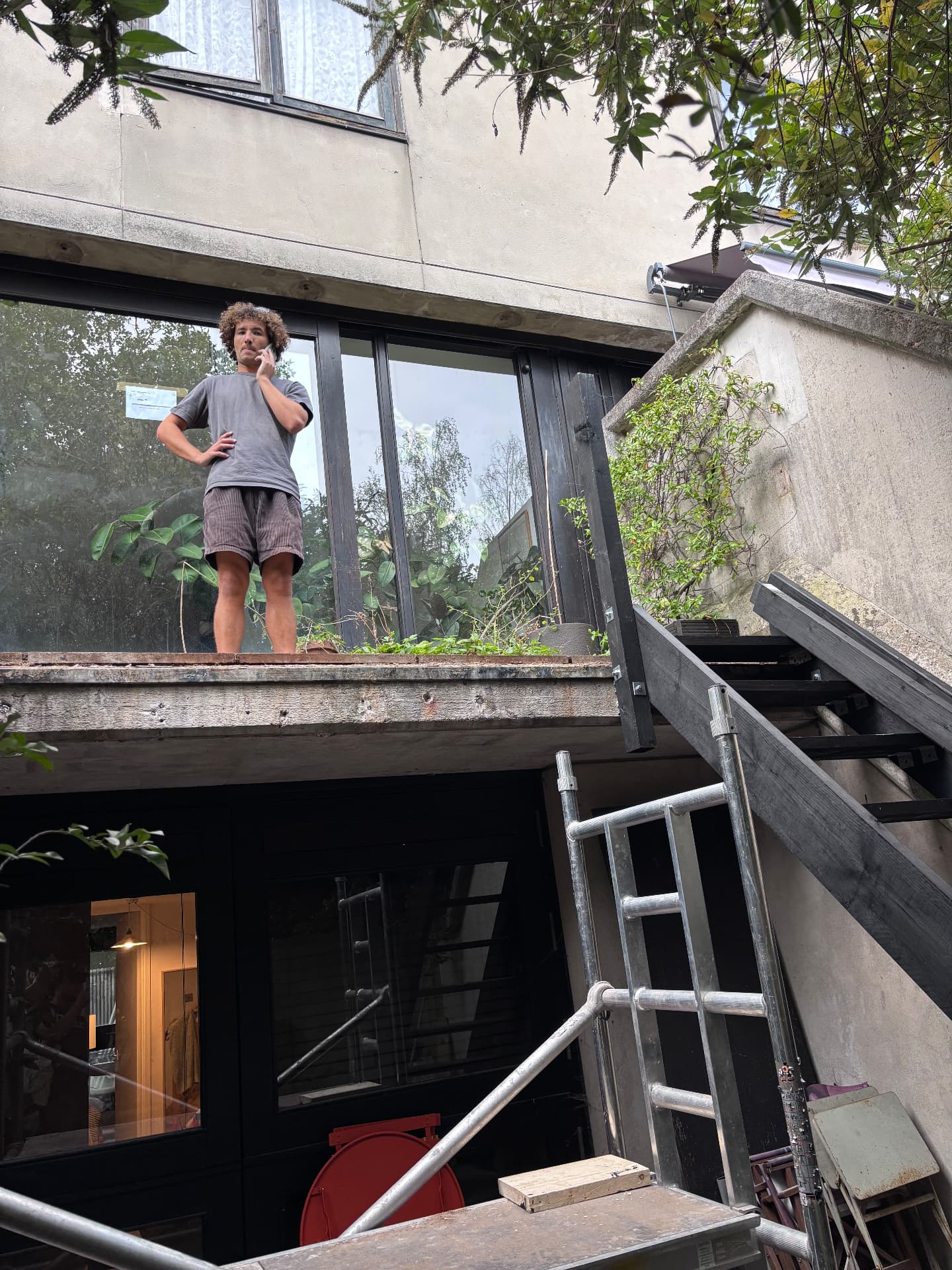 Looking up to the raised terrace mid-build with scaffold and new framing