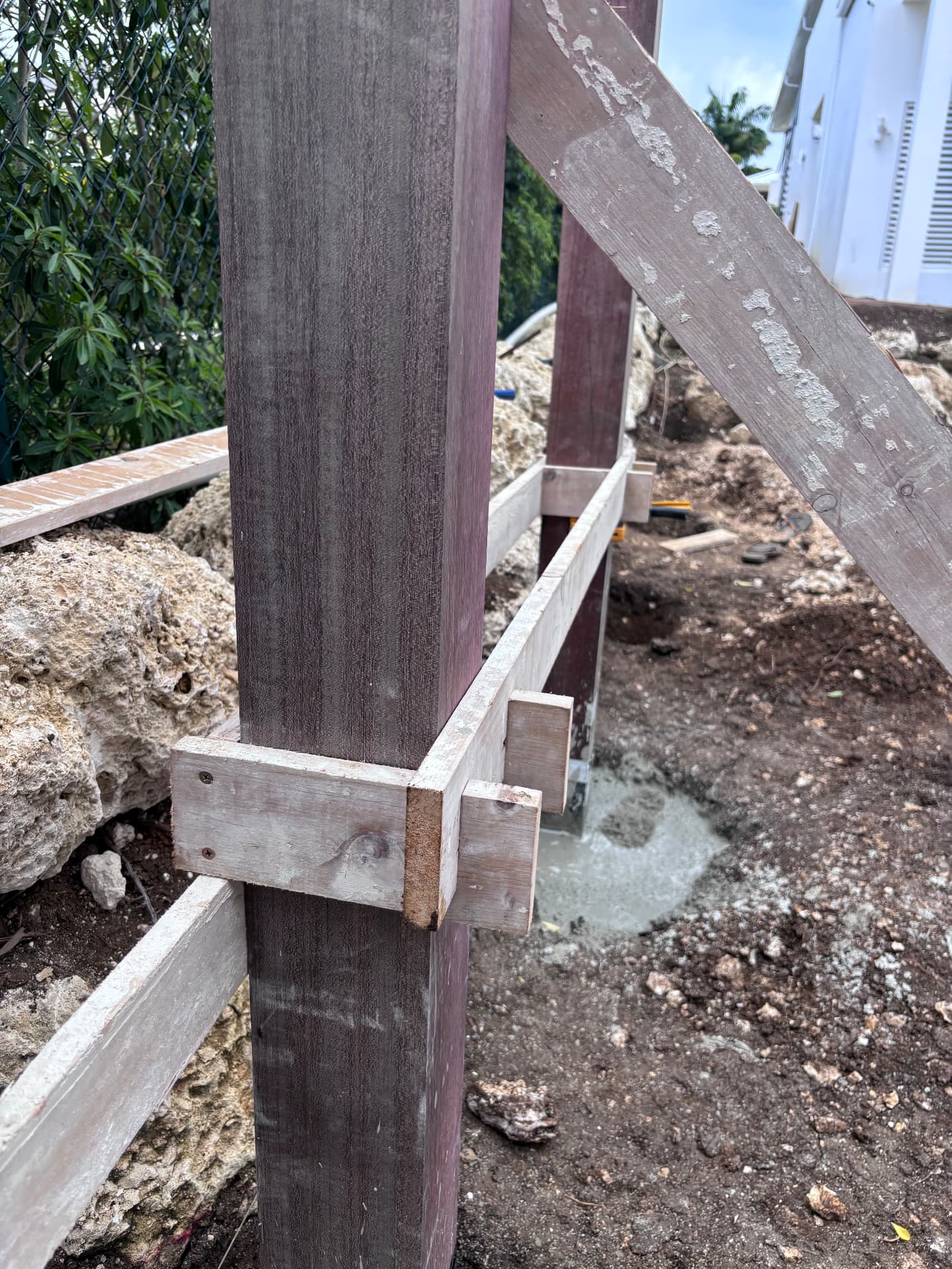 Hardwood post braced and set in concrete during pergola construction