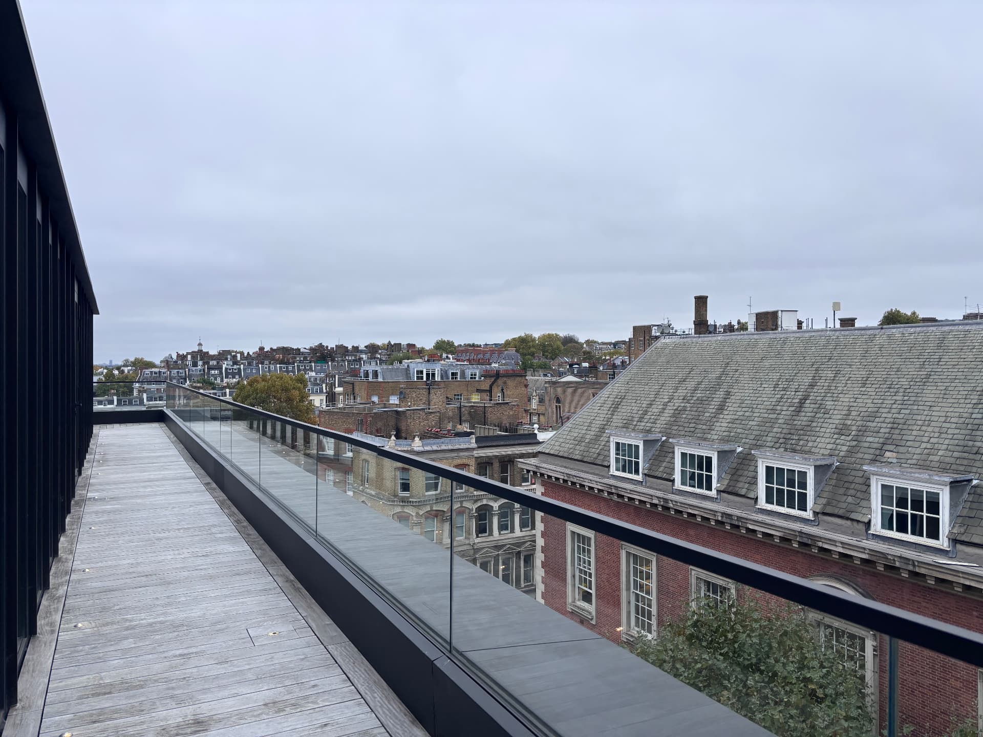 Rooftop terrace decking and glass balustrade above London slate roofs
