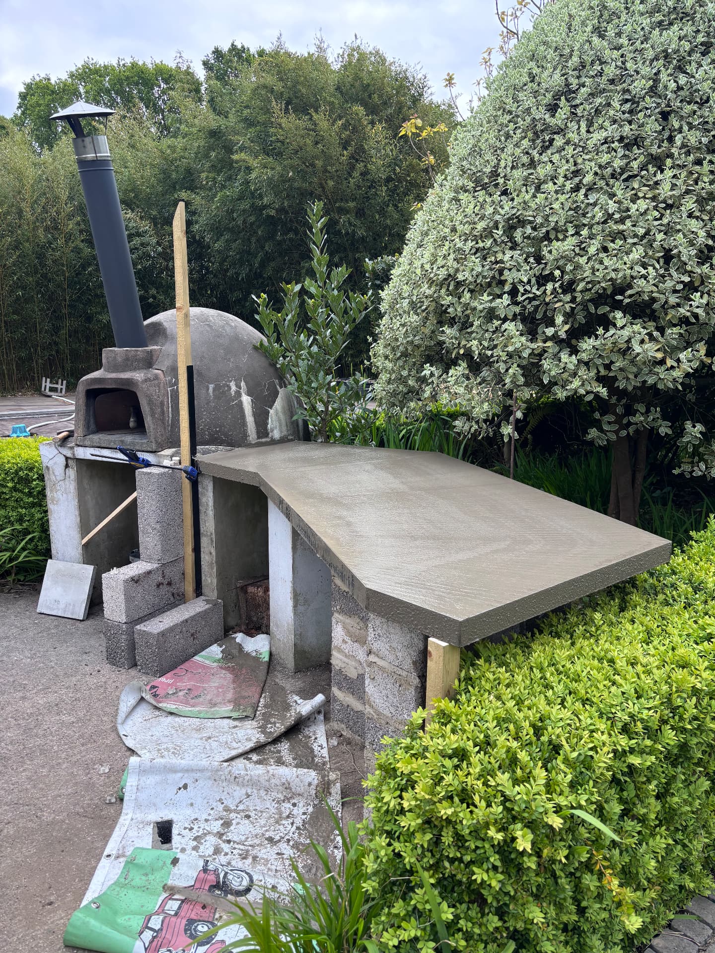 The finished cast concrete worktop curing beside the pizza oven