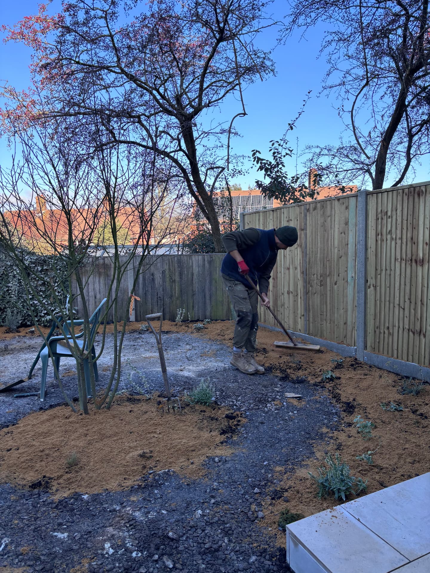 Raking soil and gravel in the new beds at Stour Close