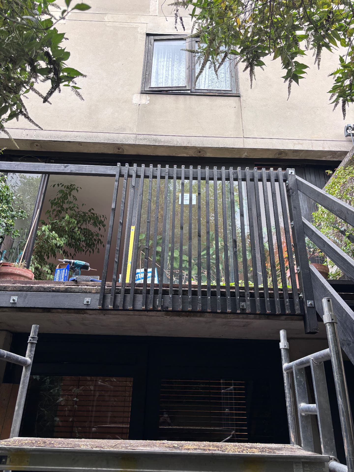 Slatted black timber balustrade completed along the raised terrace