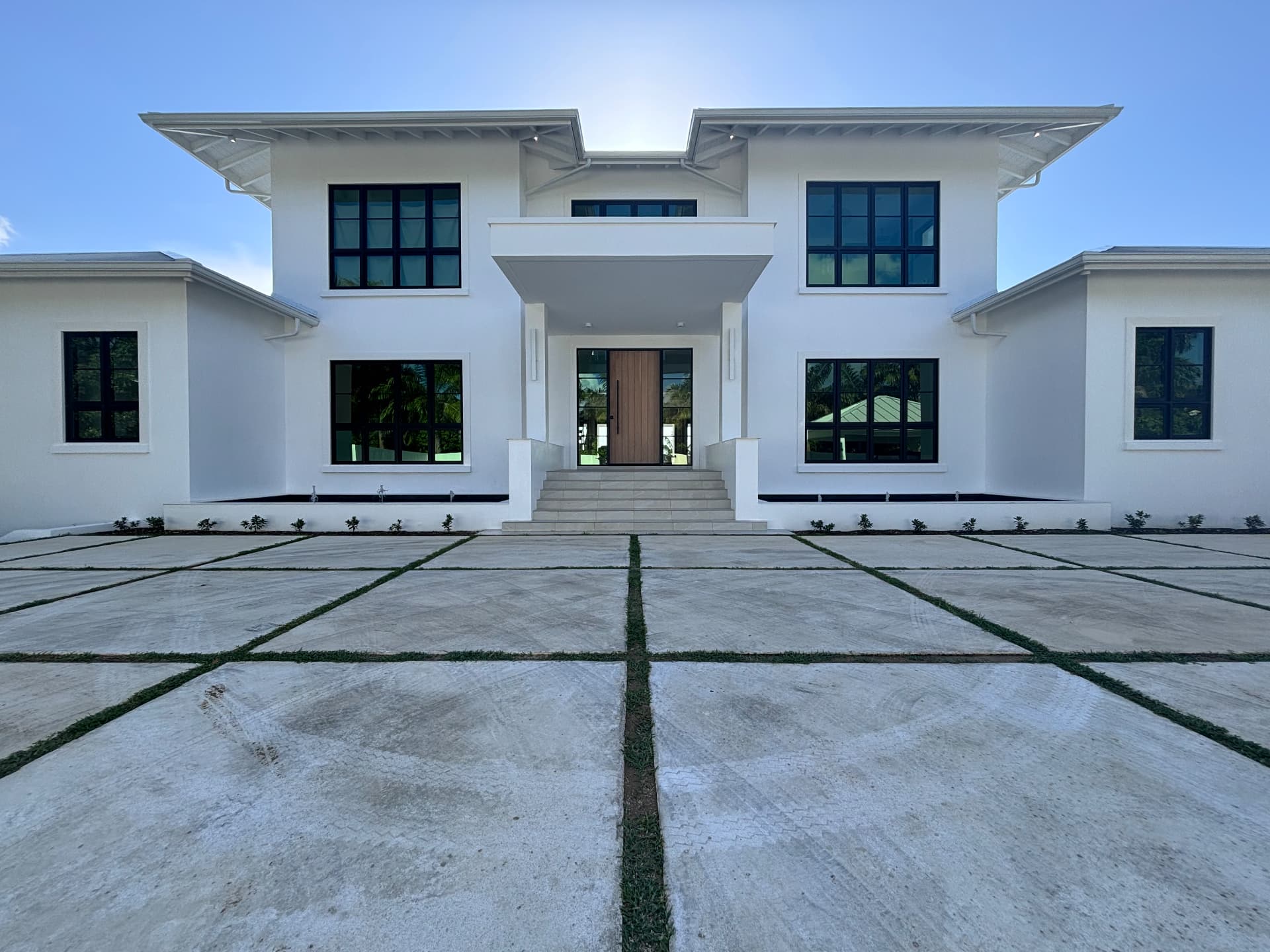 Completed villa frontage with grass-jointed paving and clipped edge planting